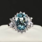A PLATINUM AQUAMARINE AND DIAMOND CLUSTER RING.