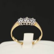 A 9CT YELLOW GOLD DIAMOND TRILOGY RING.