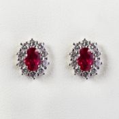A PAIR OF 18CT GOLD RUBY AND DIAMOND CLUSTER STUD EARRINGS.