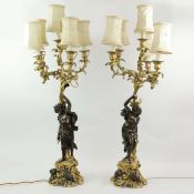 A PAIR OF FRENCH 19TH CENTURY BRONZE PARCEL-GILT FIGURAL CANDELABRA.