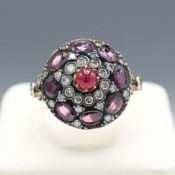 AN 8CT YELLOW GOLD RUBY AND DIAMOND CLUSTER RING.