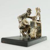 A SILVER FIGURE OF A BANK CASHIER.