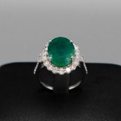 AN 18CT WHITE GOLD EMERALD AND DIAMOND RING.