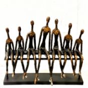 CONTEMPORARY SCULPTURE OF FIGURES ON A BENCH IN A BRONZE EFFECT FINISH.