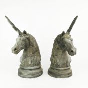 A PAIR OF BRONZE EFFECT UNICORN HEADS.
