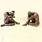 TWO CROUCHING FEMALE SCULPTURES IN RESIN.