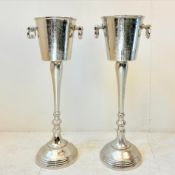 PAIR OF POLISHED METAL CHAMPAGNE BUCKETS ON STANDS WITH HANDLES.