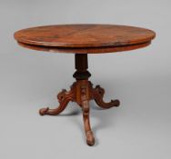 LOW TABLE WITH OVAL TOP ON CARVED TRIPOD BASE.