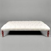LARGE HEARTH STOOL WITH NEUTRAL DEEP BUTTONED LINEN UPHOLSTERY ON TURNED SUPPORTS.