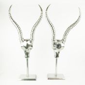 PAIR OF ANDREW MARTIN POLISHED METAL ANTELOPE HEAD SCULPTURES.