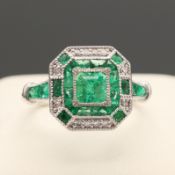 A PLATINUM EMERALD AND DIAMOND DRESS RING.