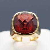 A YELLOW METAL GARNET SET RING.