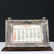 A MID-CENTURY SILVER FRAMED PERPETUAL DESK CALENDAR.