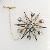 A WHITE METAL DIAMOND STAR BROOCH.