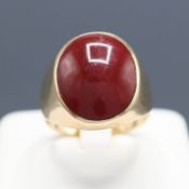 A 9CT GOLD RED CABOCHON RING.