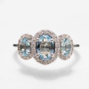 A 9CT GOLD AQUAMARINE AND DIAMOND TRILOGY CLUSTER RING.