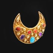 A YELLOW METAL CRESCENT SHAPED BROOCH.