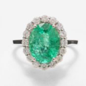 AN 18CT WHITE GOLD EMERALD AND DIAMOND CLUSTER RING.