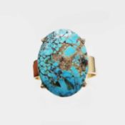 A YELLOW METAL AND TURQUOISE CABOCHON DRESS RING