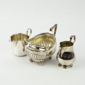 A SILVER SAUCE BOAT, A SILVER CREAM JUG AND A SILVER PLATED MILK JUG.