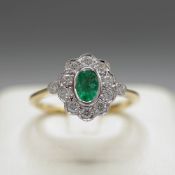 A 9CT GOLD EMERALD AND DIAMOND CLUSTER RING.