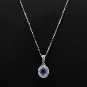 A 9CT WHITE GOLD SAPPHIRE AND DIAMOND CLUSTER PENDANT NECKLACE.
