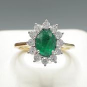AN 18CT GOLD EMERALD AND DIAMOND CLUSTER RING.