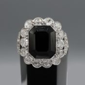 A WHITE METAL DIAMOND AND BLACK STONE DRESS RING