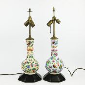 A NEAR PAIR OF CHINESE FAMILLE ROSE PORCELAIN BOTTLE LAMPS. (2)