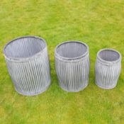 GRADUATED SET OF THREE RIBBED ZINC GARDEN PLANTERS.