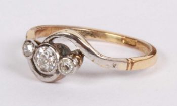 An 18 carat yellow gold and platinum diamond three stone crossover ring, size M, 2.2g