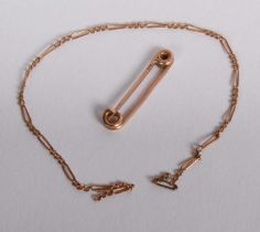 A 9 carat yellow gold safety pin, 1g, together with a yellow metal chain
