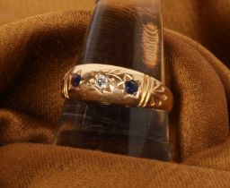 An 18 carat sapphire and diamond three stone gypsy ring, size O/P, 2.4g