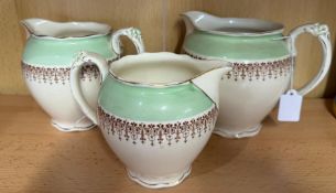 Three Wedgewood cream and green milk jugs, some damage