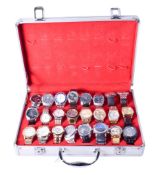 A collection of twenty-four gentlemen's wristwatches in a display case.