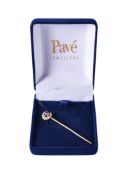 A yellow metal tie pin.