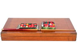 An early 20th century fold-out mahogany bagatelle bar billiards table, balls and a cue.