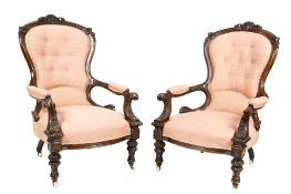 A pair of Victorian carved walnut button back open armchairs.