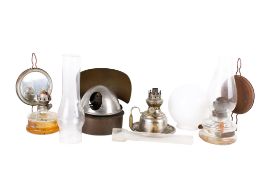 An assortment of oil lamps and shades. Including metal and glass examples, unassembled.