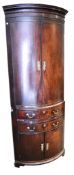 A mahogany bow fronted corner cabinet.