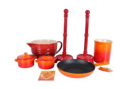 A group of four cast iron enamel Le Creuset kitchen items and two others.