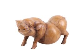 A carved wooden sculpture of a pot belly pig.