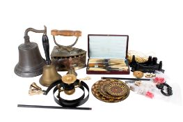 An assortment of metalware. Including bells, a set of horn handled knives, a kettle, etc.