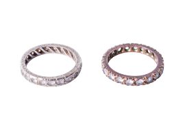 A pair of 9ct gold (tested) eternity rings, each set with synthetic white spinel. Metal not marked.