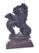 An antique cast iron doorstop in the form of a rampant lion. Raised on a stepped plinth base.