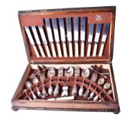 An oak canteen of silverplated flatware. Including knives and forks, teaspoons, sugar tongs, etc.