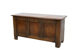 A 17th century style oak coffer. Having a three panel front with carved decoration.