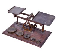 A set of vintage brass scales. With a set of weights, mounted on a rectangular wooden base, L28.5cm.