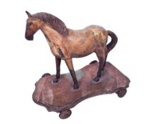 A vintage pull-along wooden model of a horse.