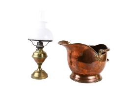 A helmet shaped copper coal scuttle and a brass oil lamp. Max.